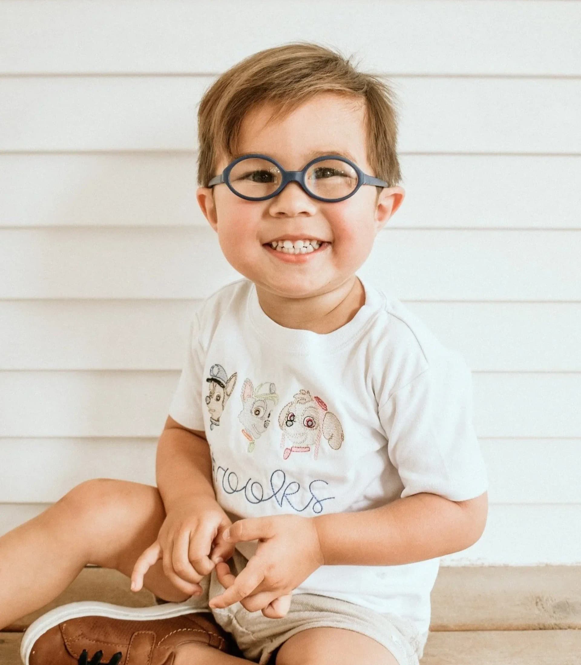 Young girl with black and pink cat-eye eyeglasses looking up